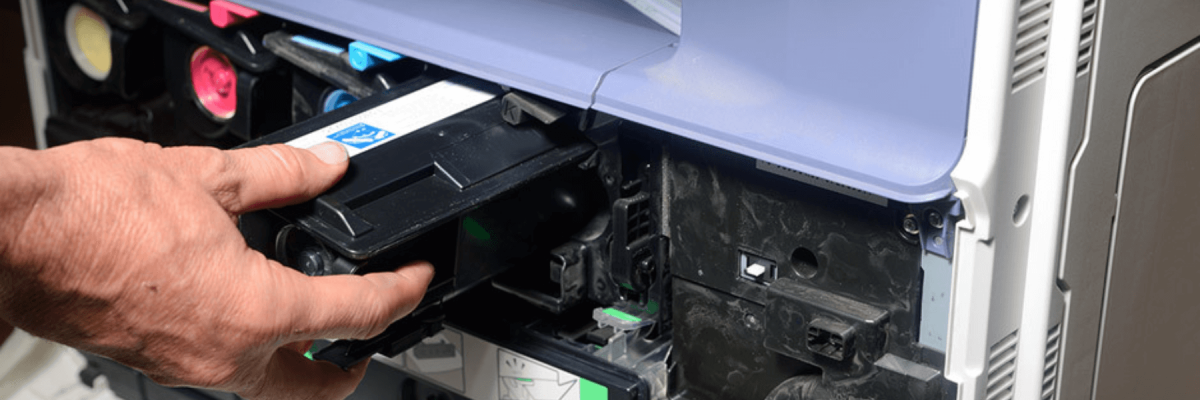 close up of a business man's hand taking out, replacing, or putting in ink or toner in an office printer, multifunction printer