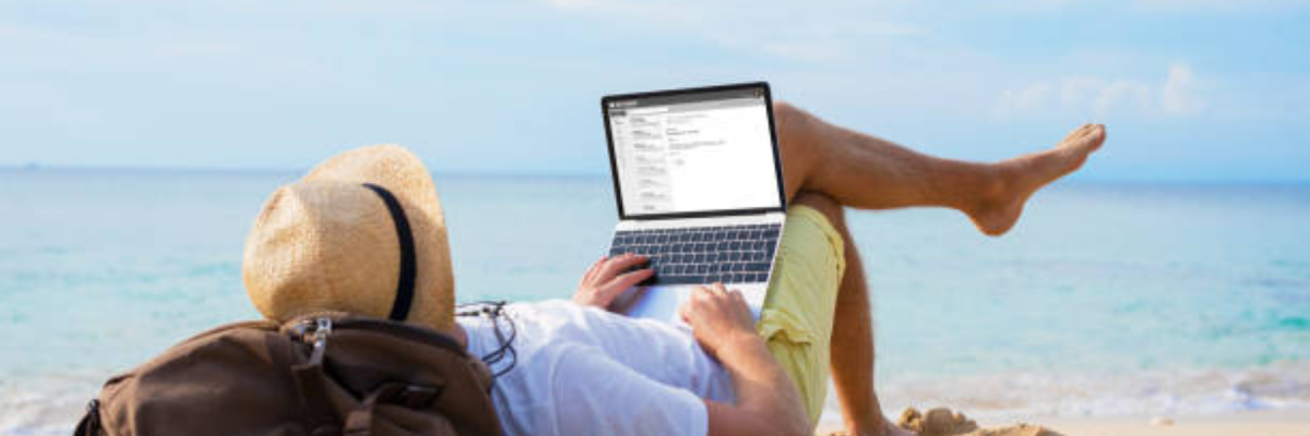 guy laying on beach with laptop